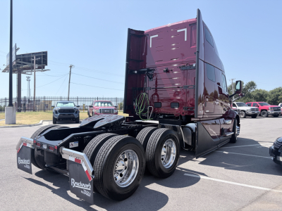 Volvo VNL64T860 truck tractor rear and side view showing fifth wheel and dual rear axles with chrome wheels and maroon cab; no visible text besides Brackeen's logo on mudflaps.
