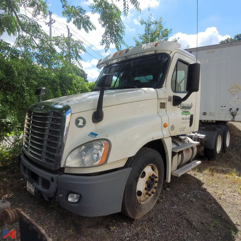 2013 Freightliner Cascadia conventional truck in a yard showing front-left view with Detroit-style grille, dual side mirrors, and attached trailer.