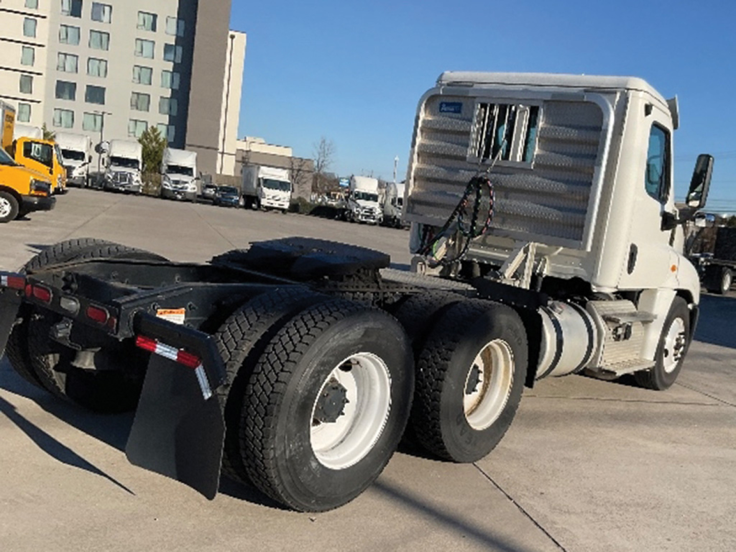 Truck chassis and cab of a 2018 Freightliner Cascadia125 daycab showing rear axle and fifth wheel, with VIN 1FUJGEDR0JLJX9087 visible in listing data.