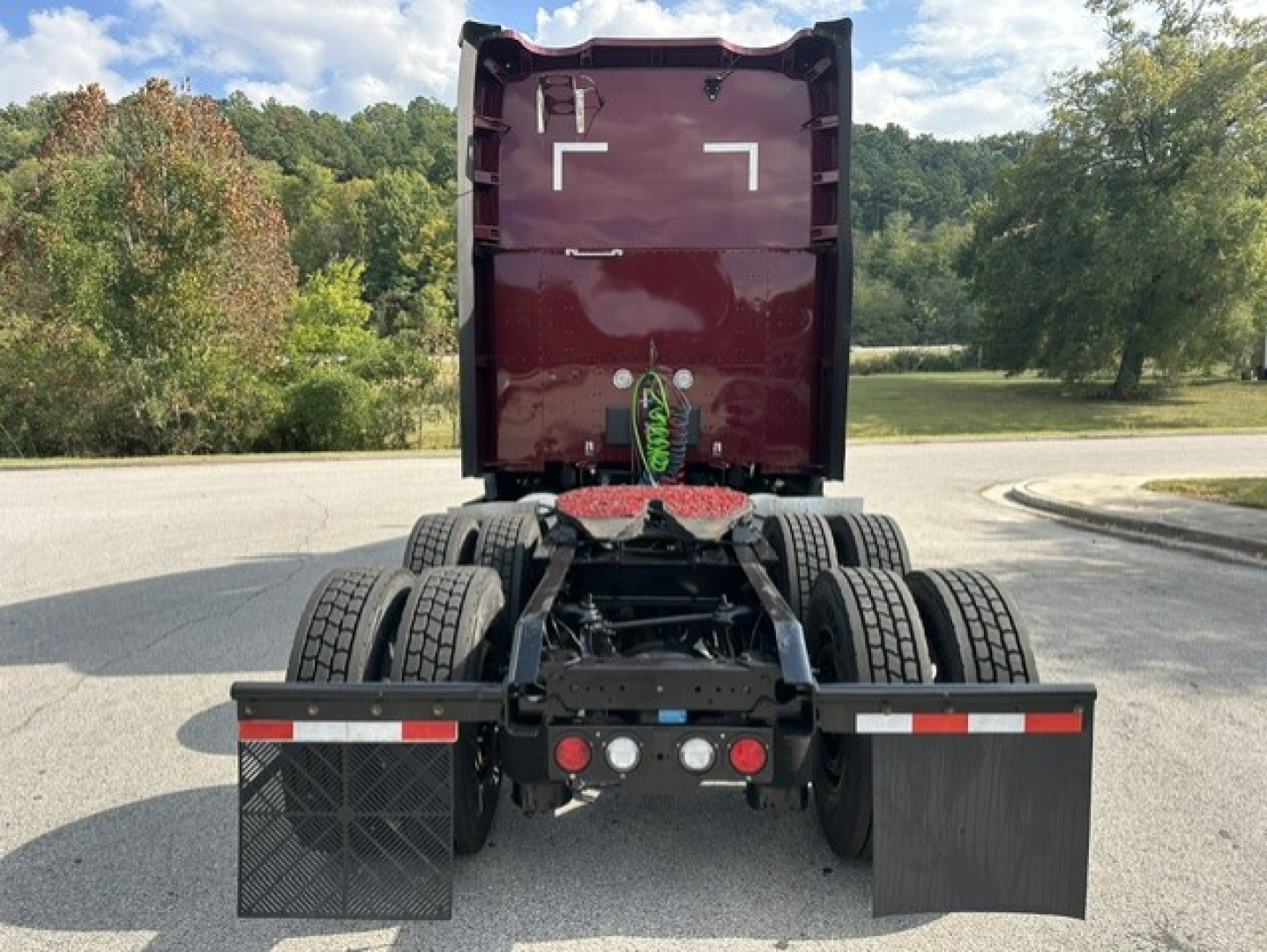 Kenworth truck rear view showing chassis and fifth wheel with dual rear axles and mudflaps.