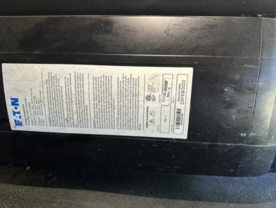 Vehicle data plate on black dash of 2023 Kenworth T680 showing Kelly blue label with text and barcodes.