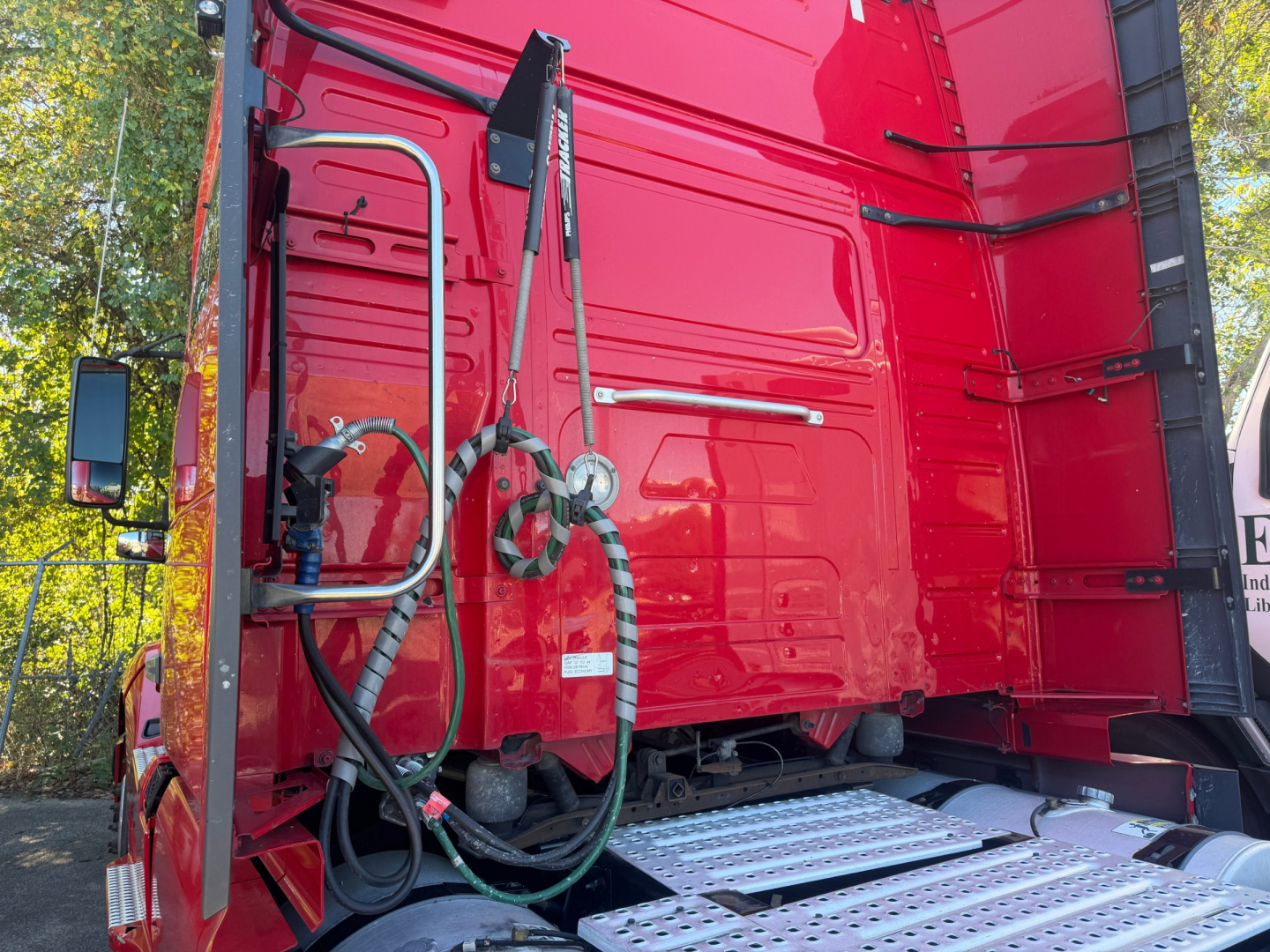 Volvo VNL64T760 truck rear sleeper bay with fuel hoses and ladders showing connectors and silver steps.