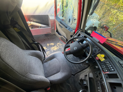 Truck cab interior of a 2022 Volvo VNL64T760 showing driver's seat, steering wheel, dashboard, and door area.