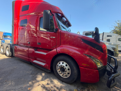 Volvo VNL64T760 sleeper cab truck in red, front-left view showing aerodynamic hood, large side mirrors, and wheel rims.