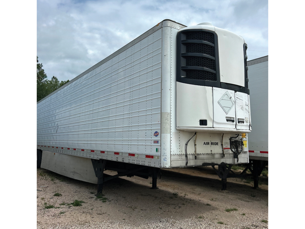 Trailer side view showing reefer unit at front of a 2014 Utility 3000R refrigeration trailer with white body, front unit with black vents and cooling unit.