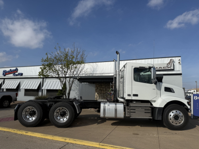 Volvo VHD64FT300 daycab truck in side profile showing cab and rear chassis with dual rear axles.