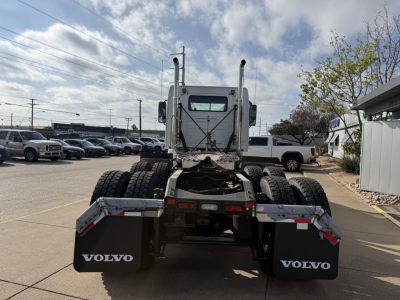Volvo VHD64FT300 tractor rear view showing dual rear axles, fifth wheel, and Volvo mud flaps with white Volvo logo.