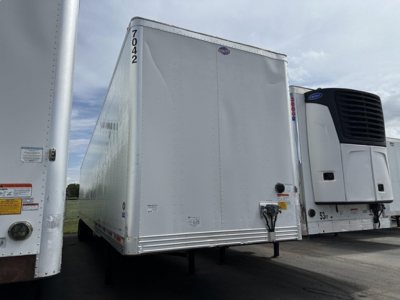 Utility trailer 2017 4000D-X with front hitch and hanging numbers, side doors, silver aluminum exterior. Seen next to a white refrigerated tractor unit.