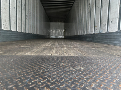 Empty Utility trailer interior with metal walls and wood floor, Diamond plate at the threshold.
