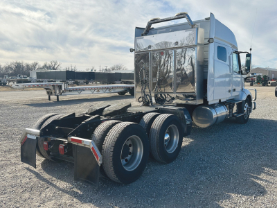 2022 Volvo VNL 740 tractor rear view showing third axle, fuel tanks, and polished chrome toolbox area.