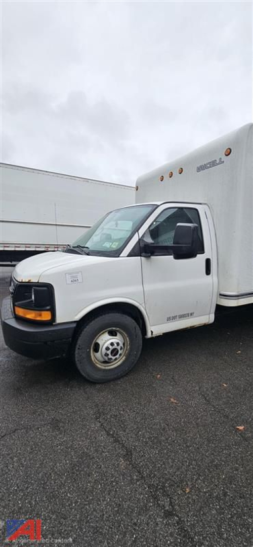 GMC Savana 3500 cutaway box truck side view showing front cab and cargo box with GMC logo on the hood; driver door; white exterior