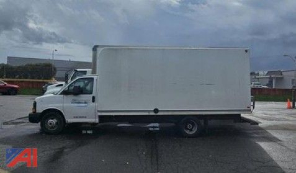 GMC Savana 3500 cutaway box truck side view with cargo box, white. In-service vehicle