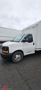 GMC Savana 3500 cutaway box truck side view showing front cab and cargo box with GMC logo on the hood; driver door; white exterior