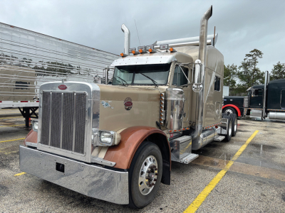 Peterbilt 379 UltraCab extended hood truck in beige with chrome accents and dual exhaust stacks, front chrome grille, large bumper, and tandem rear wheels.