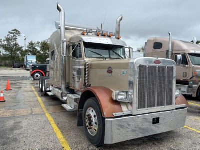 Peterbilt 379 UltraCab Extended Hood truck in beige with chrome details, dual vertical exhaust stacks, large chrome grille, and long hood. Front bumper and fenders with metal step, multiple amber marker lights on cab roof. VIN tag not visib
