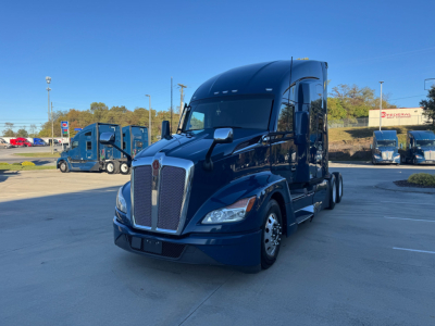 Kenworth T680 tractor cab in blue viewed from front-left showing aerodynamic sleeper and grille