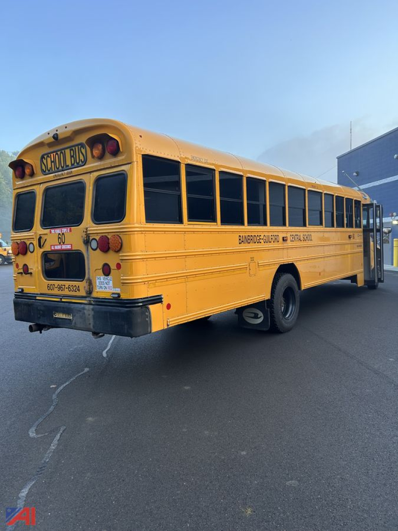 School bus rear/side view with yellow body, black windows, and text visible: 'SCHOOL BUS' on rear upper panel, '60' on stop sign area, phone number on rear bumper area, and another line of text along the side reading 'BANGOR-GURR' or simila