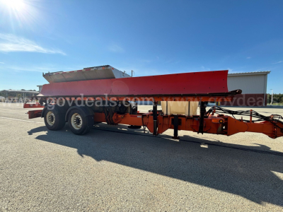 Mack GU Granite plow truck trailer showing red/silver plow blade on orange chassis and dual rear axles.