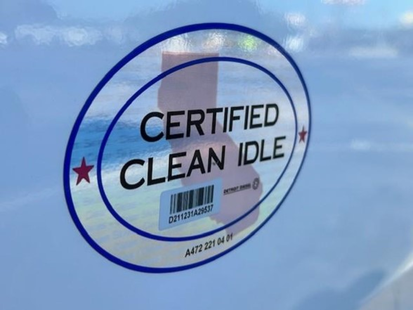 Sticker on Freightliner Cascadia showing Certified Clean Idle logo with barcode and circular blue ring.