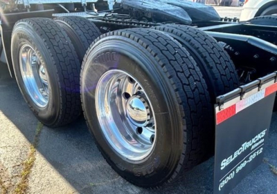 Freightliner Cascadia 126 rear wheels and dual tires on trailer dolly showing polished rims and tread pattern.