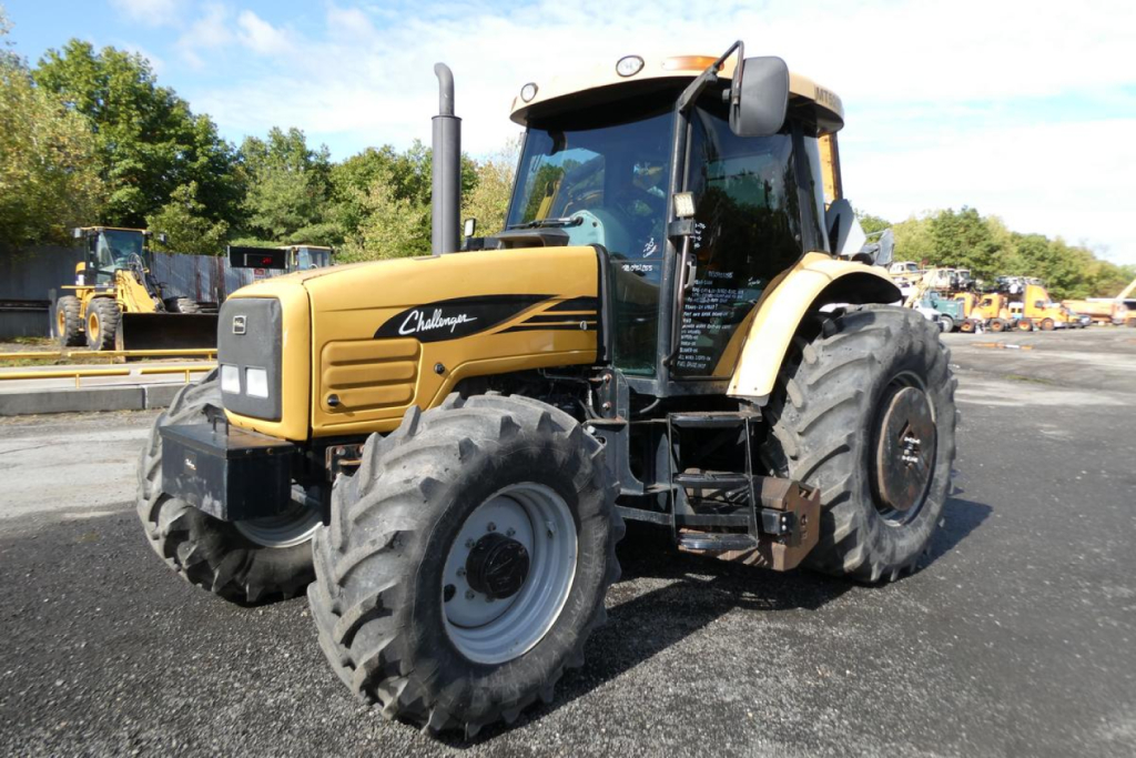 Challenger MT525B tractor in a yard showing front-left view with large tires and cab; yellow and black body with Challenger logo visible.