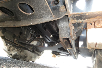 Underbelly view of a 2005 Challenger MT525B tractor showing exposed chassis, hydraulic lines, and drivetrain components.