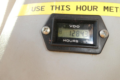 Hour meter reading 1284.3 hours in a Challenger MT525B tractor display area with yellow warning tape above.