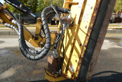 Challenger MT525B tractor attachment with hydraulic hoses and metal frame, showing control lines and yellow paint.