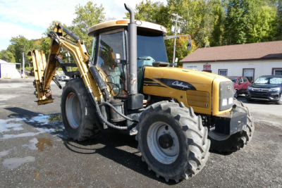 Backhoe loader tractor with front tires and rear excavator arm, labeled Challenger on side, with cabin and hydraulic system visible.