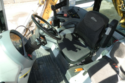 Cab of a Challenger MT525B tractor from the operator’s seat perspective showing steering wheel, dashboard controls, and seat with visible pedals.