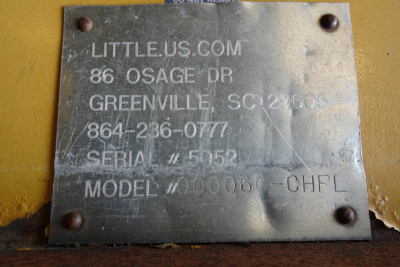 Metal nameplate with engraved text including LITTLEUS.COM, 86 OSAGE DR, GREENVILLE, SC 29609, 864-236-0777, SERIAL 5052, MODEL 000006, CHFL