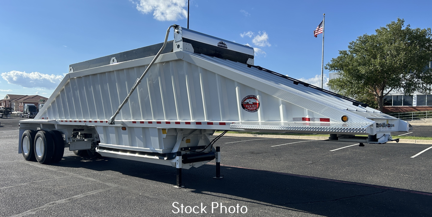 Dump trailer showing side view with silver body and dual rear axles, safety chains, and landing gear; stock photo label present.