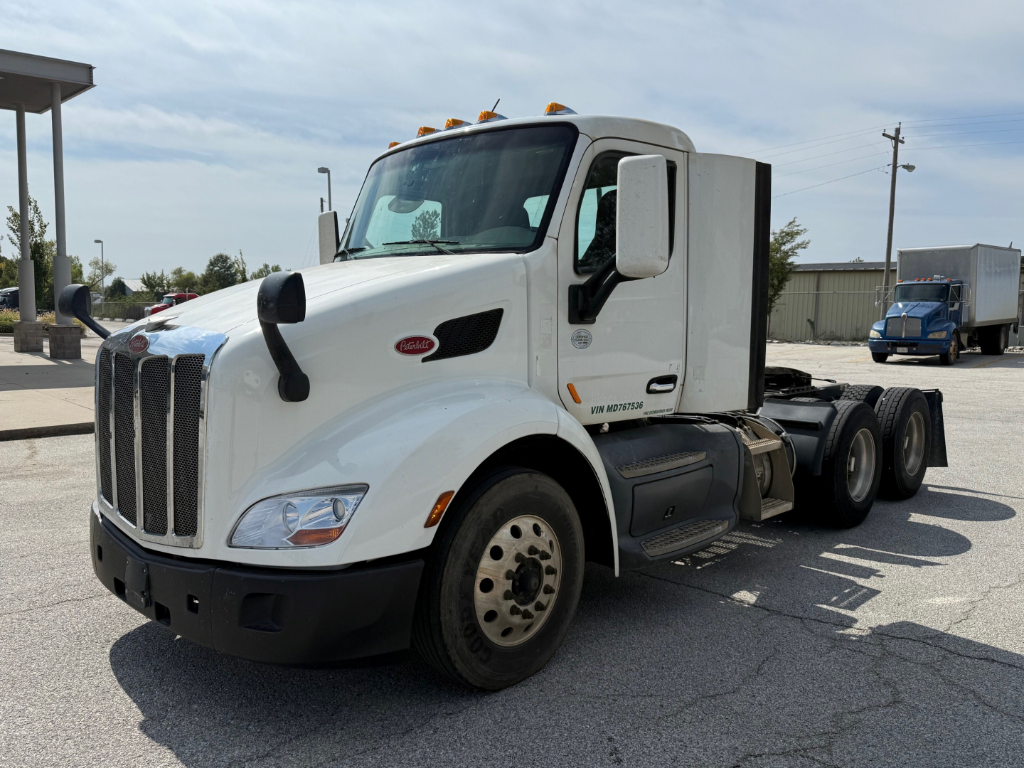 Peterbilt 579 conventional daycab truck in white, front-left view, no trailer, three axles at rear, VIN 1XPBDP9X1MD767536 visible on listing, stock 0629857.