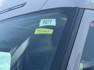 Volvo VNL64T860 truck windshield showing stock number 70065 and tag 9071 in the interior