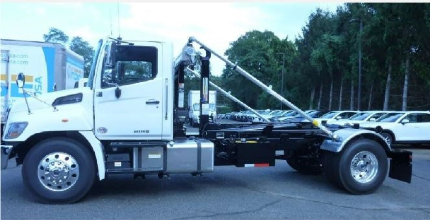 Hino L7 hooklift truck side view showing cab, chassis, and hooklift arm with hydraulic hoist.