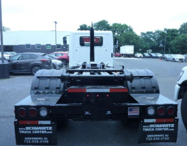 Rear view of a 2027 Hino L7 hooklift truck showing the chassis and back details with dual rear wheels and taillights.