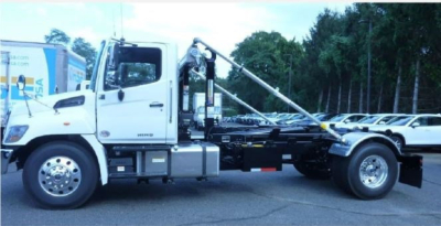 Hino L7 hooklift truck side view showing cab, chassis, and hooklift arm with hydraulic hoist.