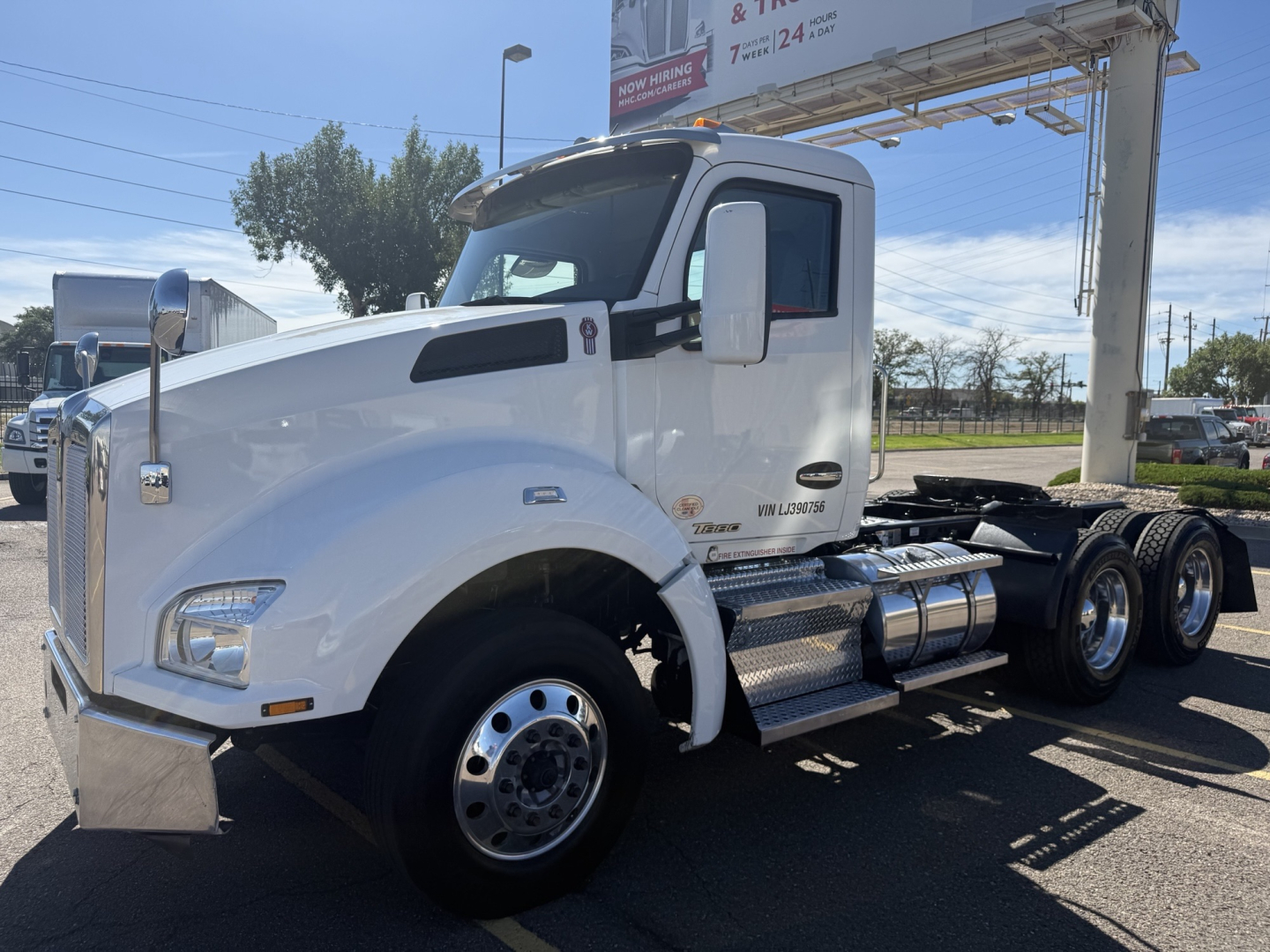 2020 Kenworth T880 conventional daycab truck with white cab, side exhaust, chrome fuel tanks, and dual rear wheels. Visible text on cab includes Kenworth emblem and T880 model badge; no specific fluid labels readable.