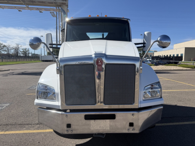 Kenworth T880 front view showing chrome grille, dual round mirrors, large bumper, and badge on grille.