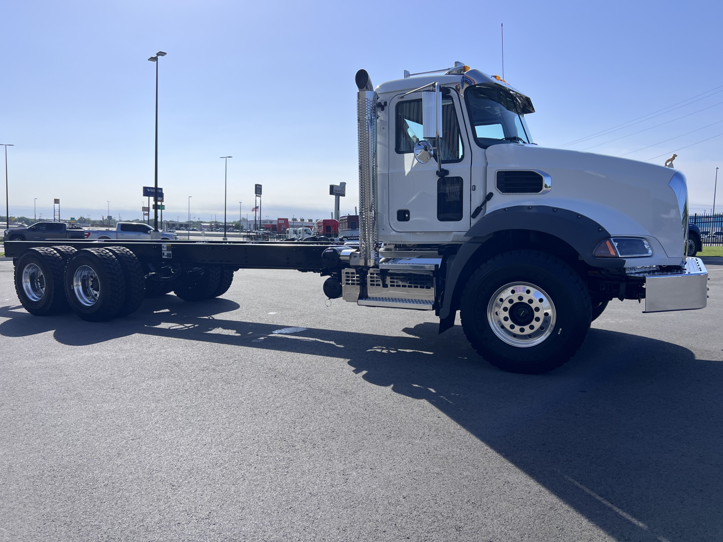 Mack GR64B cab chassis truck side view showing front cab and chassis frame with dual rear axles and exhaust stack.