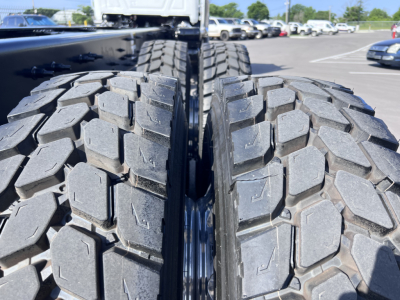 Mack GR64B truck dual rear tires close-up showing heavy tread blocks and gap between tires.