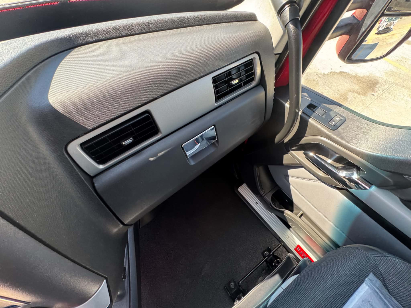 Kenworth T680 interior dash area showing passenger-side glove box and center console details with air vents.