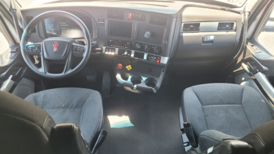 Kenworth T680 truck cabin dashboard and steering wheel with two seats, control switches, and digital displays visible.