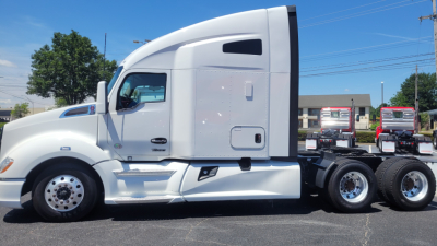Kenworth T680 sleeper tractor in white, side view showing cab and rear axles with chrome wheels.