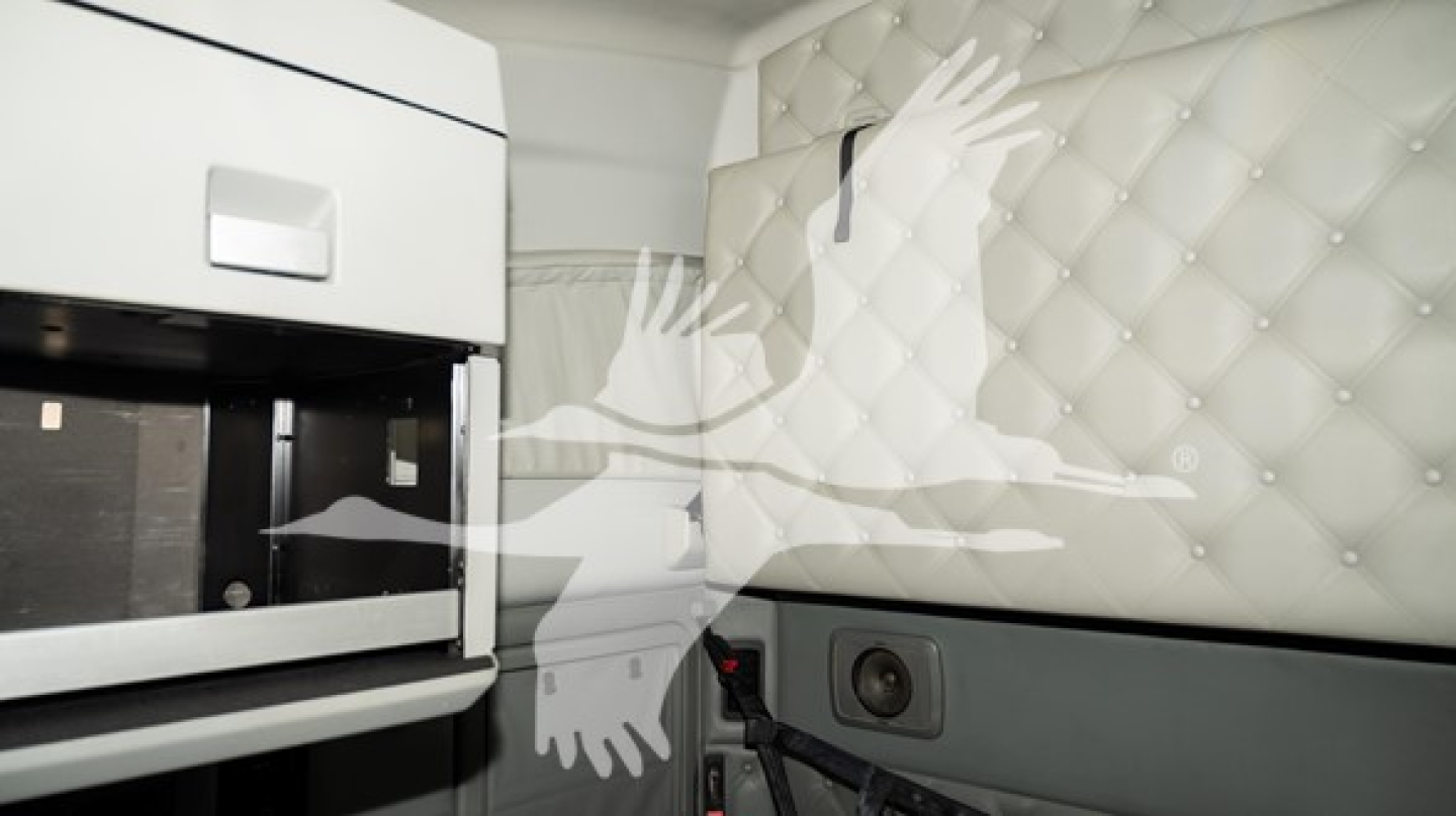 Kenworth T680 cab interior showing quilted sleeper wall and storage area with speaker