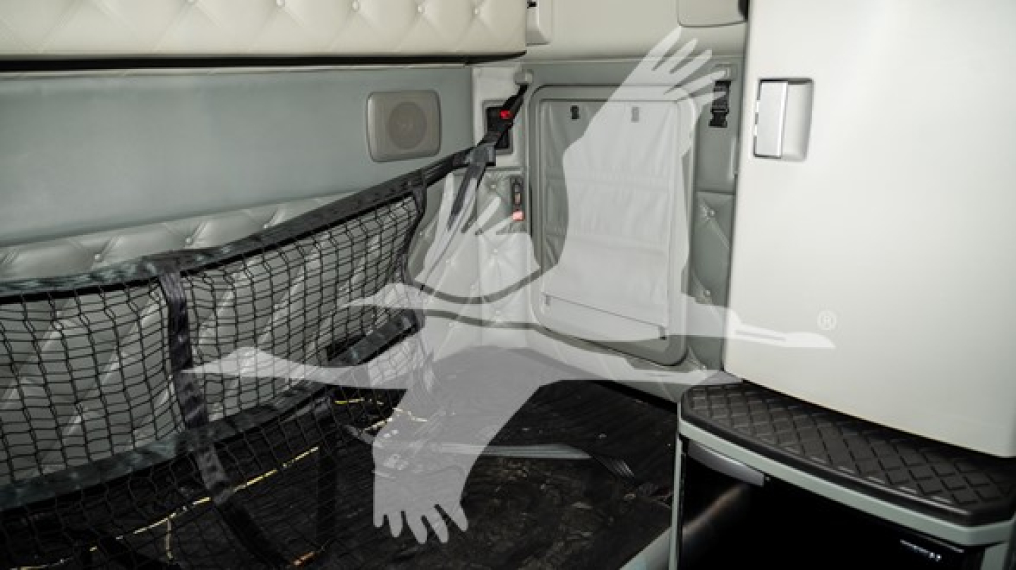 Kenworth T680 truck interior showing sleeper area with safety net and storage compartments.