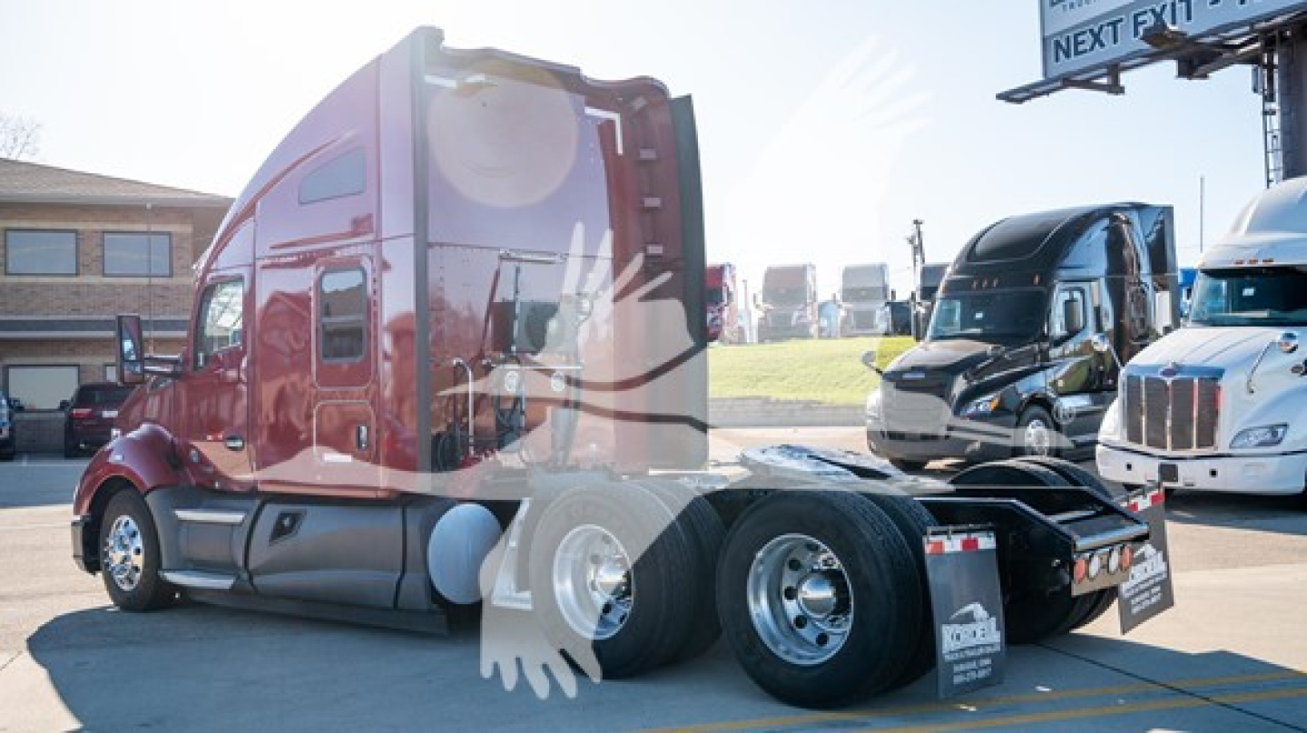 Semi tractor rear and cab view showing red Kenworth T680 with sleeper cab, chassis, and dual rear axles.