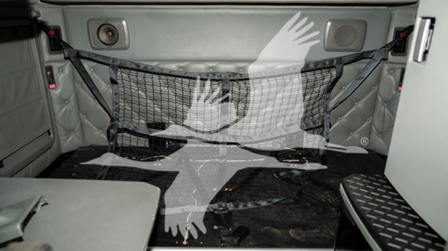 Kenworth T680 truck sleeper interior back area with cargo net and side storage; interior panels and floor visible.