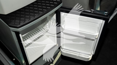 Kenworth T680 cab interior showing open under-bench refrigerator-freezer? and compact fridge with shelves and door shelves.