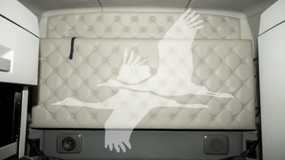 Vehicle interior wall with tufted white padding and a large stylized bird graphic; no legible text visible.